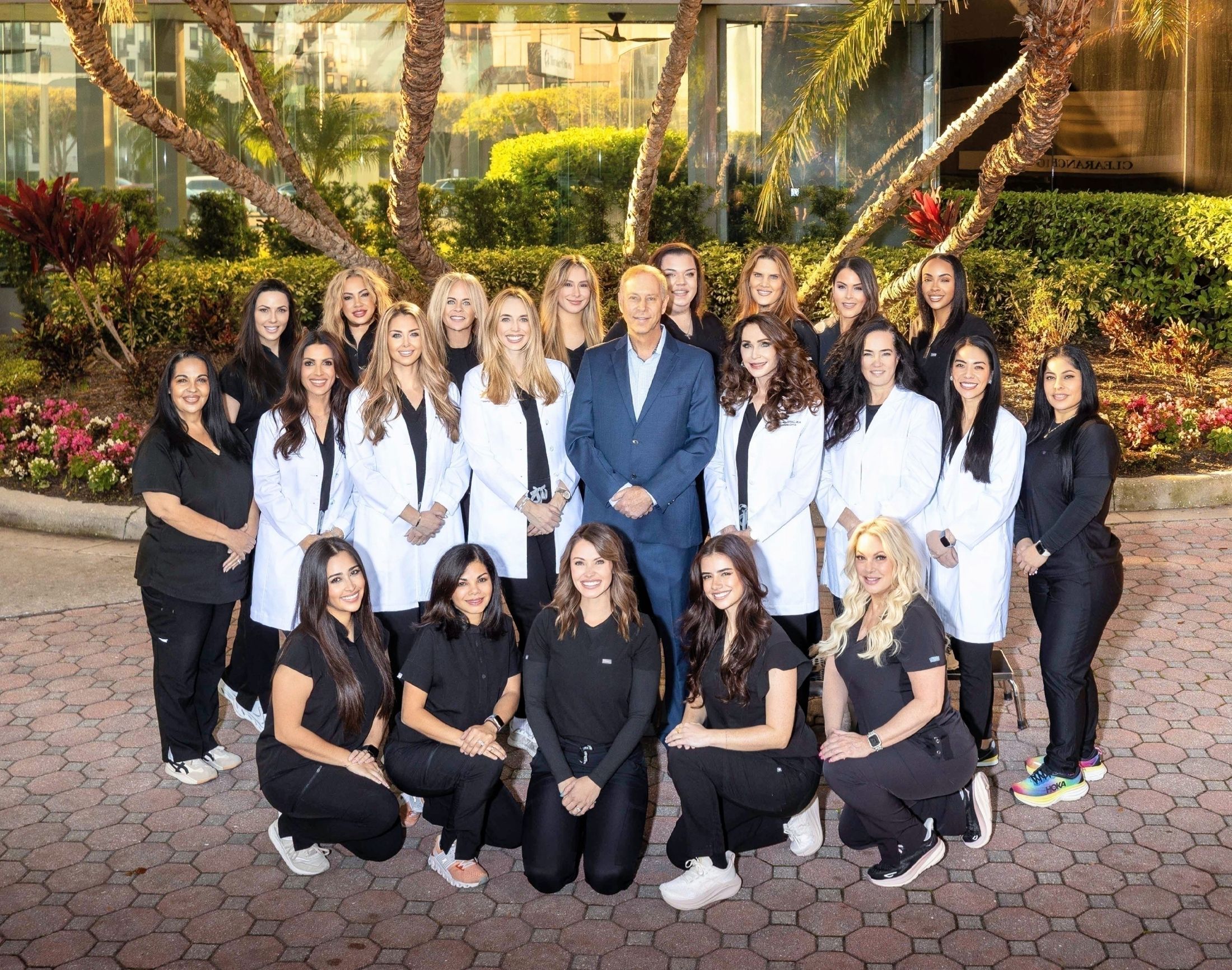 Medical team posing outdoors in professional attire.