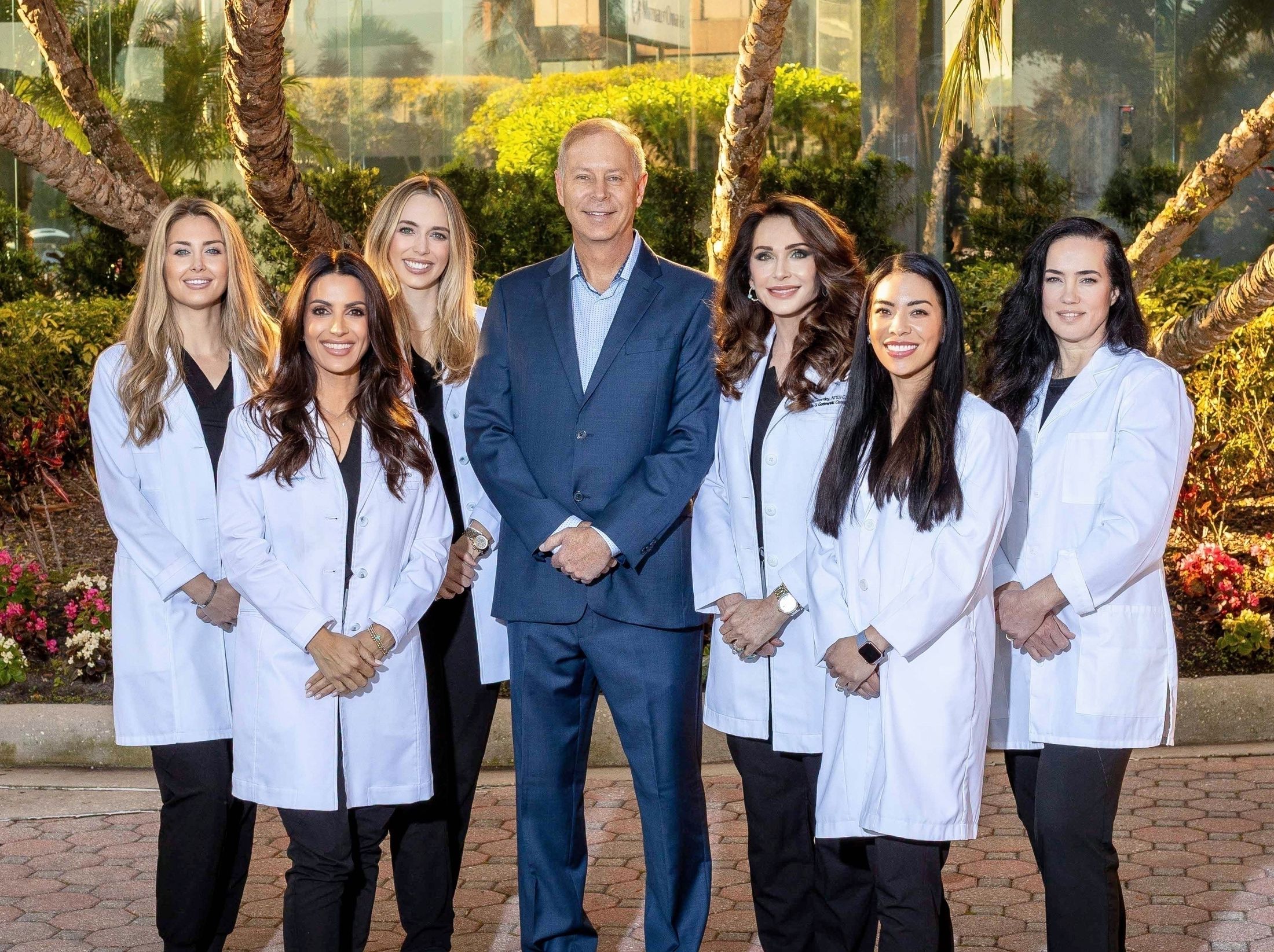 Medical team posing outdoors in professional attire.