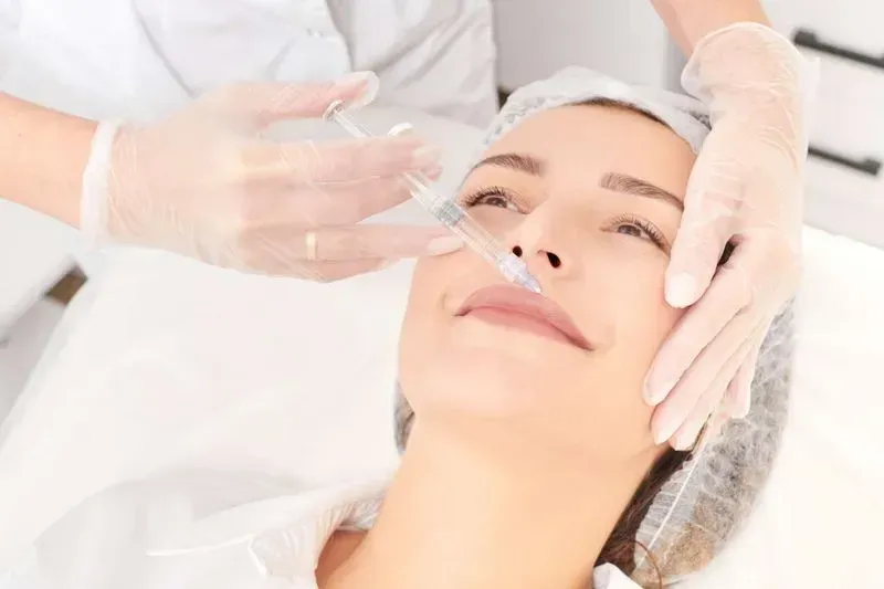 Woman receiving cosmetic injection treatment in clinic.