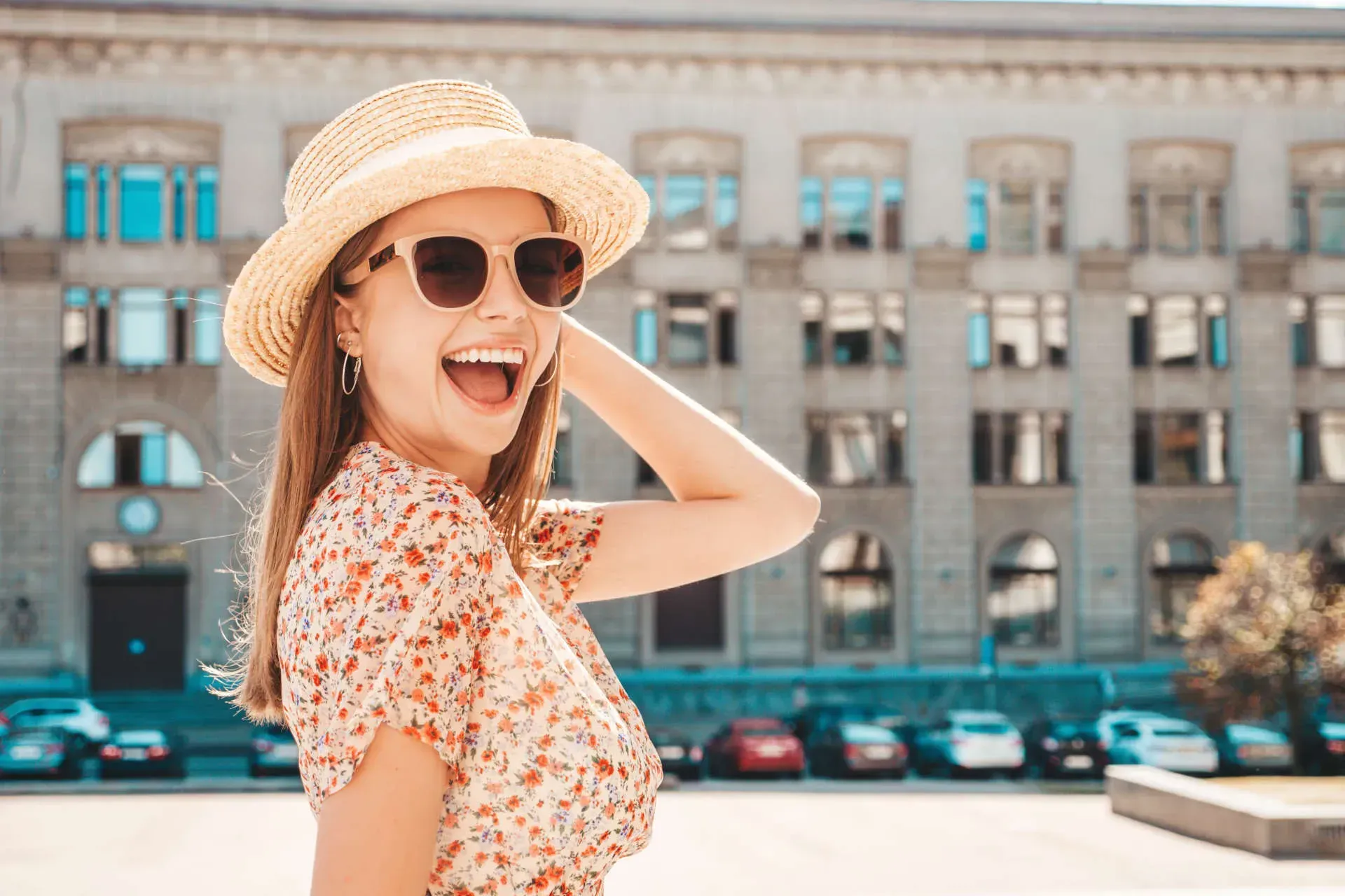 Smiling woman in sunglasses and straw hat.