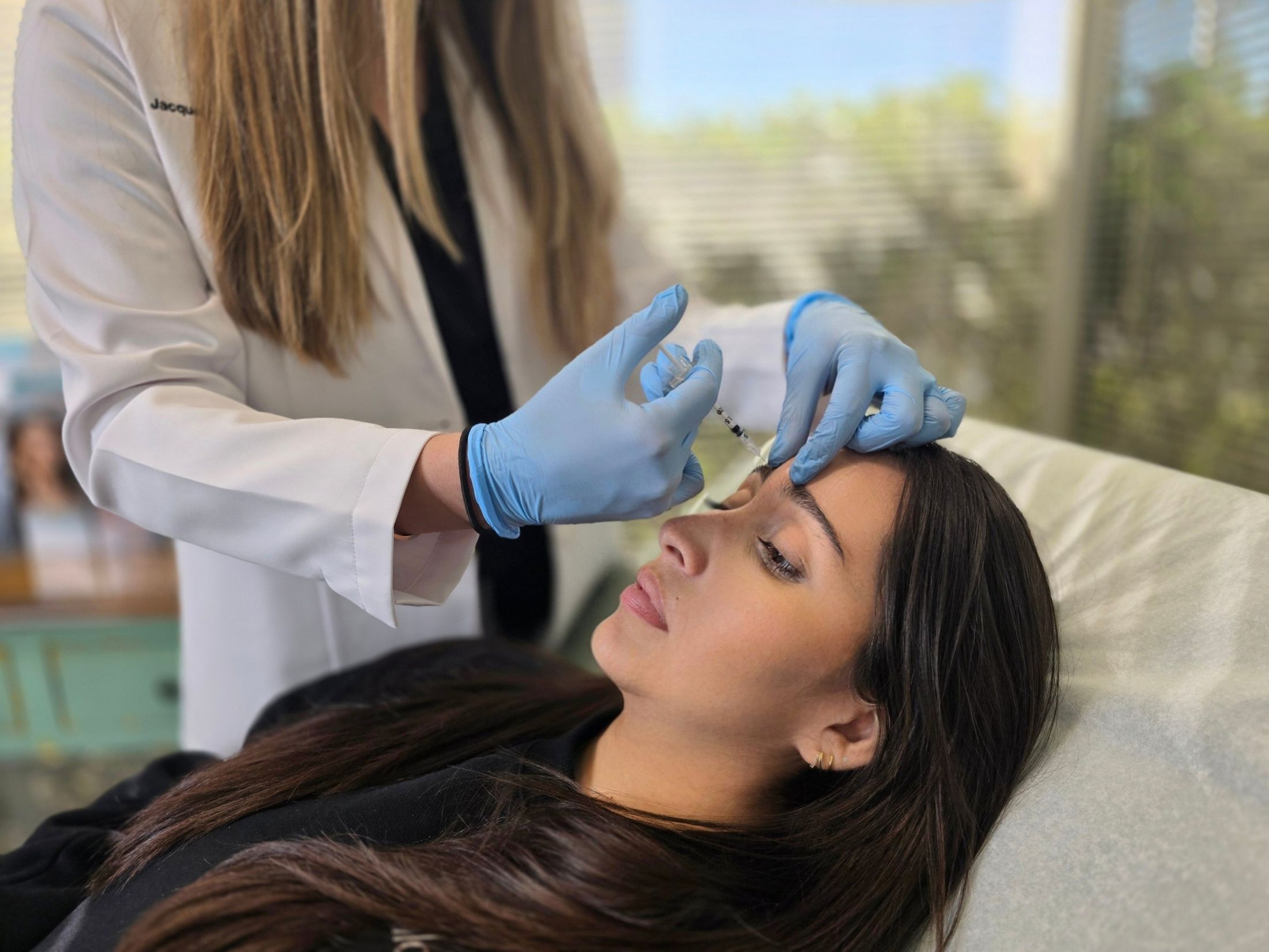 Cosmetic procedure with syringe on lips.