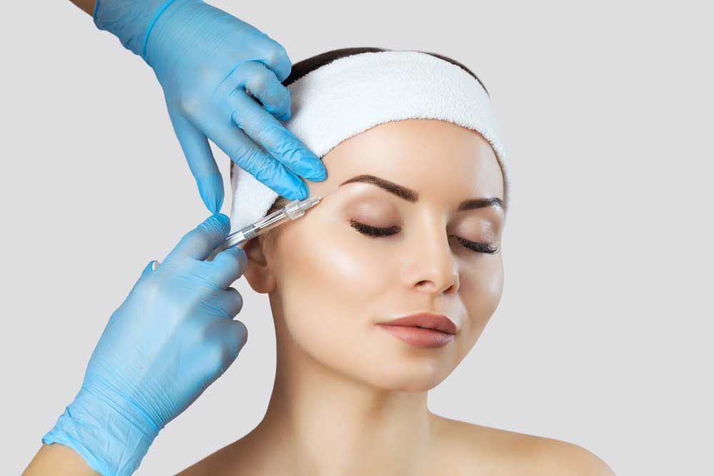 Beauty treatment procedure with syringe and model.